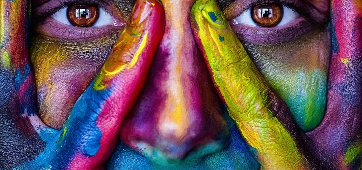 Kuvassa on sateenkaarivärein meikatut kasvot.