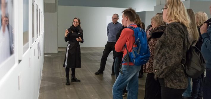 Opas Laura Porola kertoo yleisölle Alec Sothin näyttelystä syksyllä 2016. Kuva: Virve Laustela / Suomen valokuvataiteen museo.