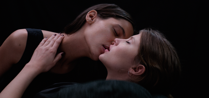 kuvassa kaksi naista lähes suutelee toisiaan