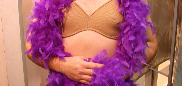 Kuvassa on miesoletettu, jolla on ihonväriset rintaliivit ja höyhenpuuhka