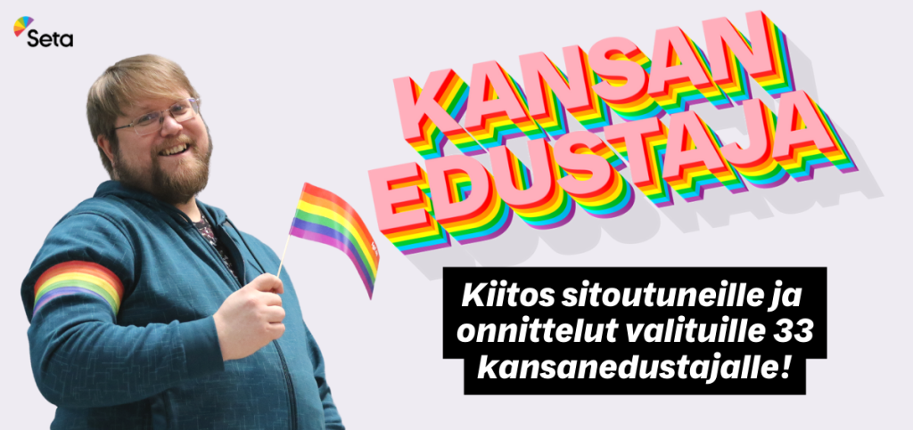 Hymyilevä Setan puheenjohtaja Pekka Rantala heilutta pientä sateenkaarilippua. Toisessa käsivarressa on sateenkaarinauha.