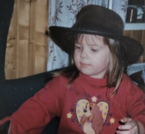 Kuvassa Vikke lapsena. Lapsella päässä musta cowboy-hattu ja päällä punainen paita, jossa on koiran kuva.