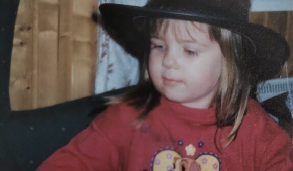 Kuvassa Vikke lapsena. Lapsella päässä musta cowboy-hattu ja päällä punainen paita, jossa on koiran kuva.